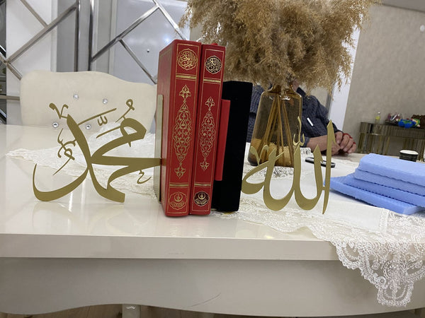 Masada altın renkli Muhammed ve Allah lafızları, yanında kırmızı ciltli kitaplar