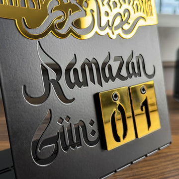 Masaüstü Ramazan takviminde 'Ramazan Gün' yazısı ve değiştirilebilir altın sayı blokları, yakın çekim