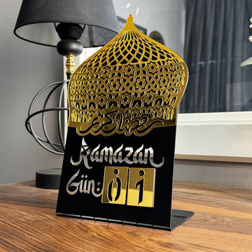 Siyah metal gövdeli, altın akrilik kubbeli masaüstü Ramazan takvimi, Gün 01 yazılı, masada
