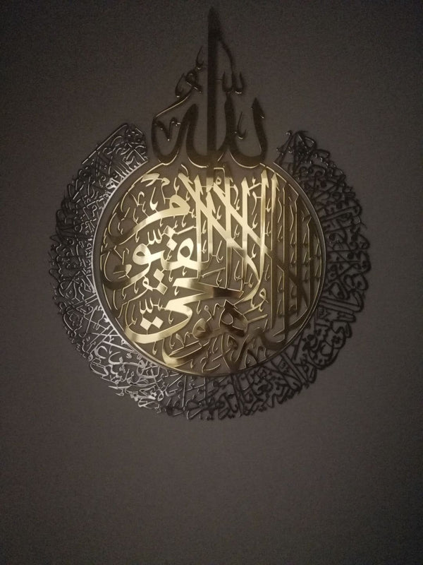 Karanlık zeminde altın ve gümüş renkli metal Ayetel Kürsi detayı