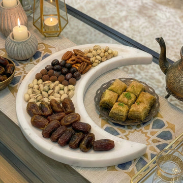 Ramazan hilali mermer servis tabağı, hurma, kuruyemiş ve baklavayla iftar sofrasında