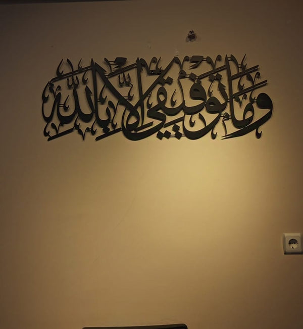 Sarı tonlu duvarda siyah "Ve mâ tevfîkî illâ billâh" hattı