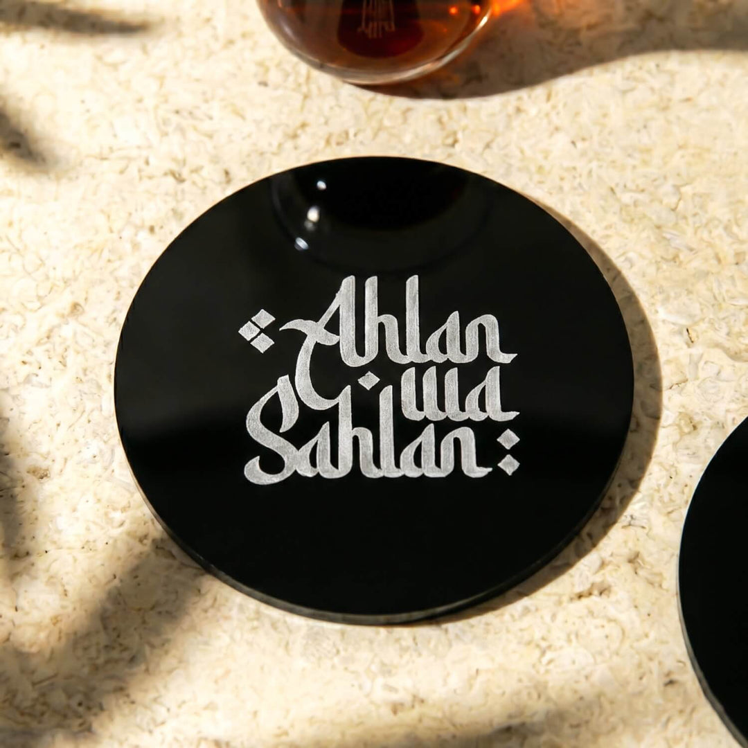 Latin harfli Ahlan wa Sahlan yazılı siyah akrilik bardak altlığının yakın görünümü