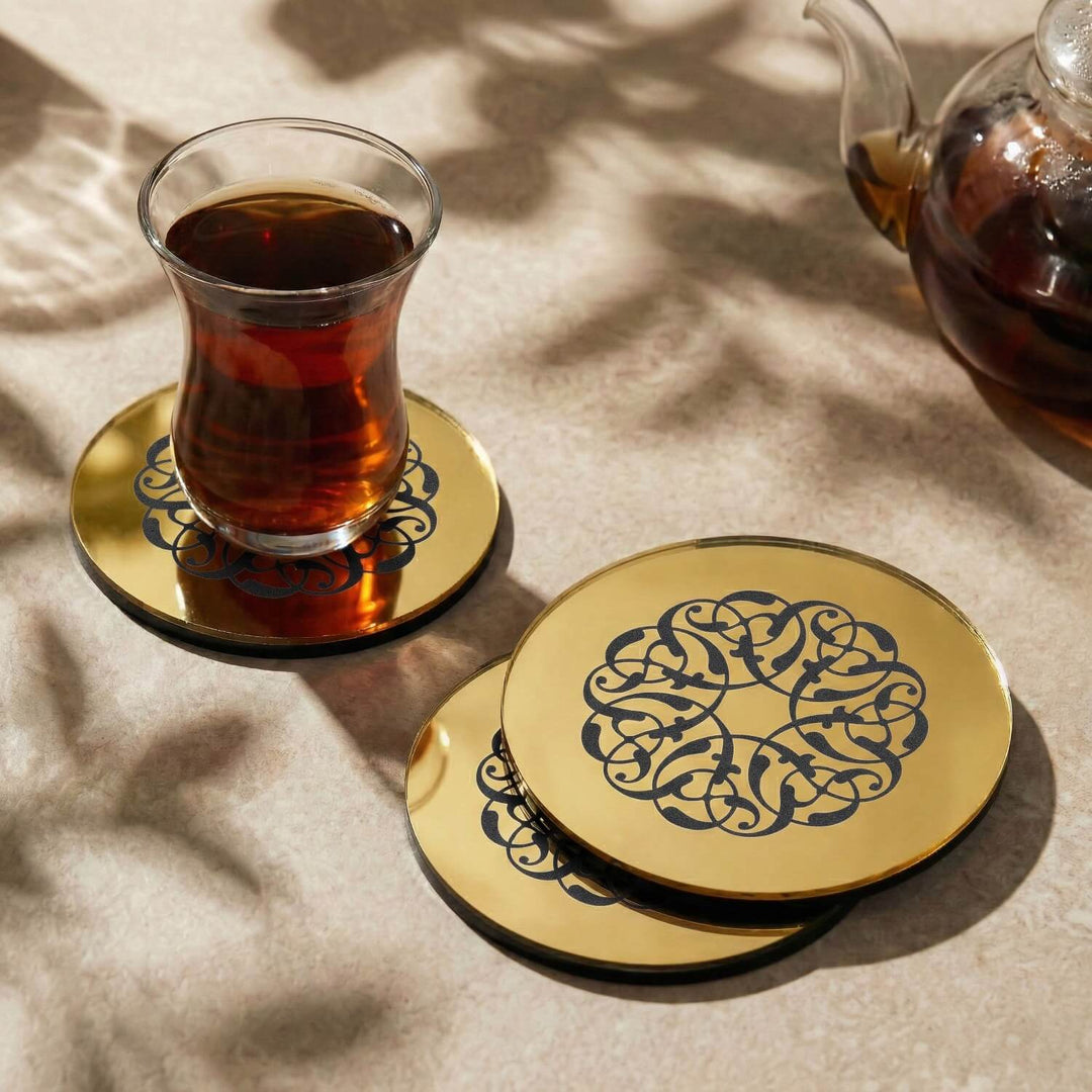 Rumi Desen altın akrilik bardak altlığı, üzerinde çay bardağı ve yanında iki altlık