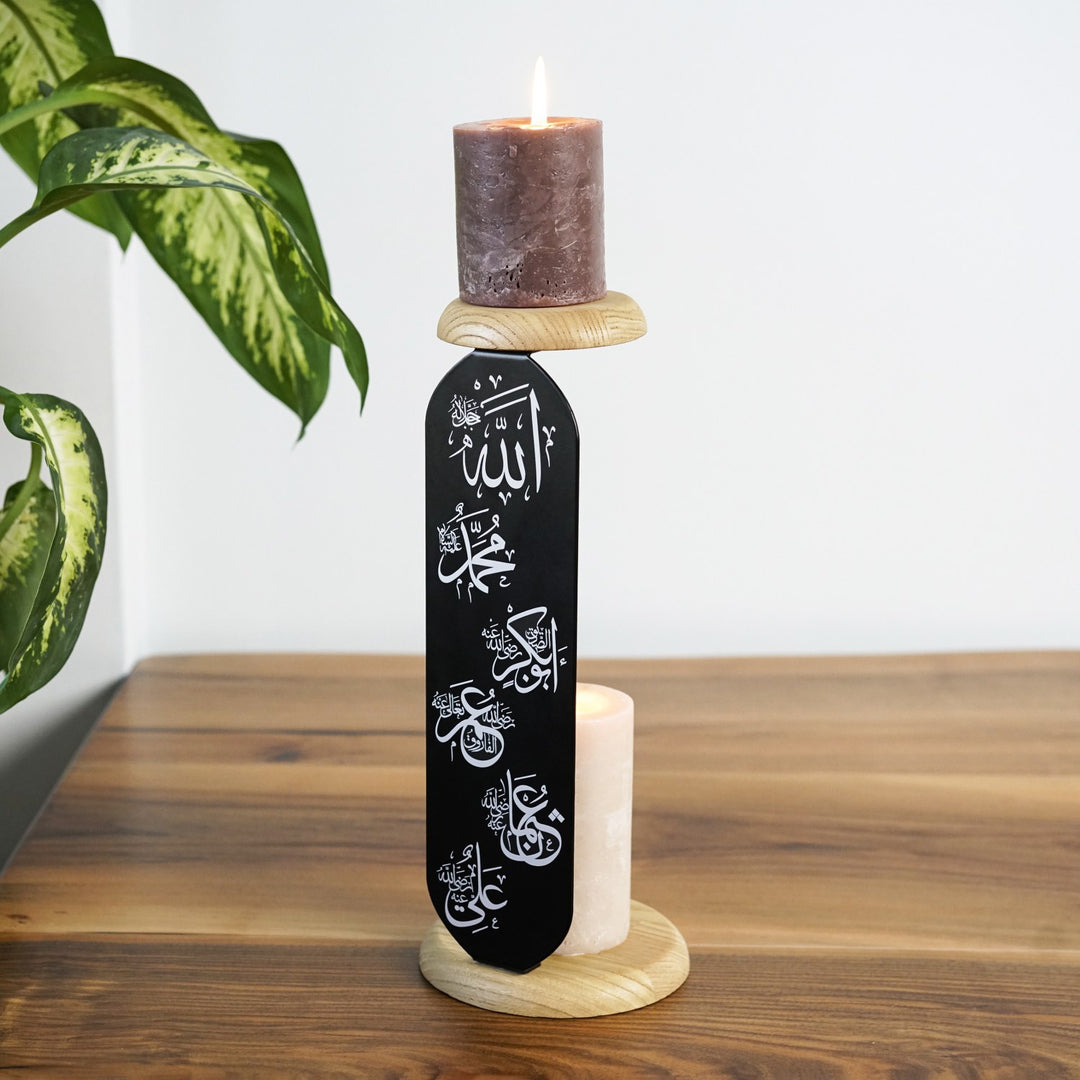 yan acidan gorulen allah muhammed ve hulefai rasidin yazili siyah metal mumlugun iki ahsap standinda yanan mumlar gorunuyor islamicwallarttr