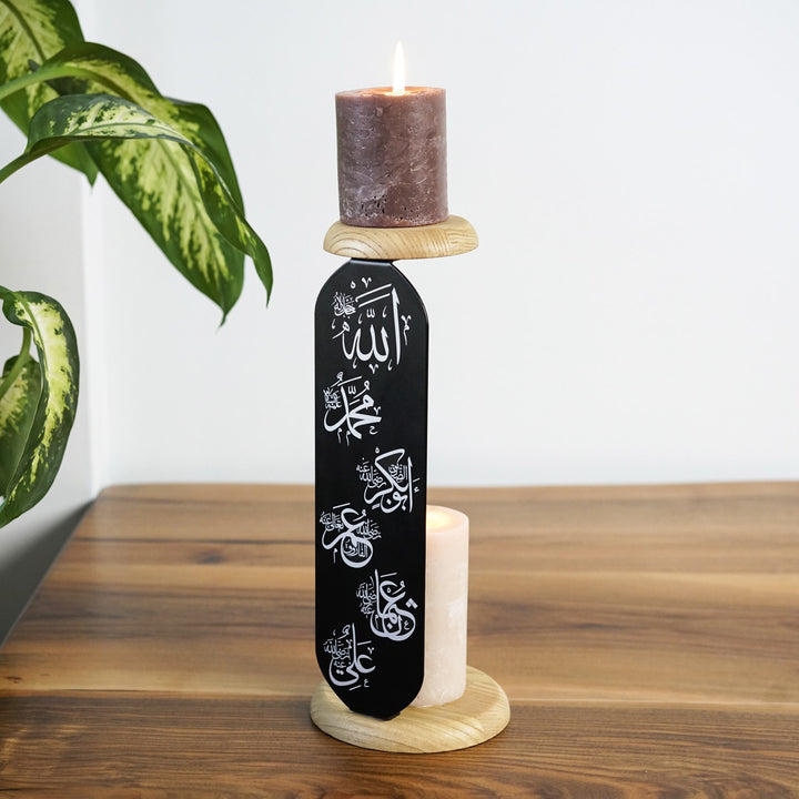 yan acidan gorulen allah muhammed ve hulefai rasidin yazili siyah metal mumlugun iki ahsap standinda yanan mumlar gorunuyor islamicwallarttr