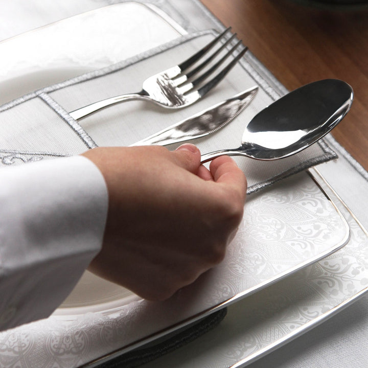 islamicwallart tasarimi olan bu beyaz kumas yemek setinde gumus rengi islemeli servis cebi icerisinde catal bicak ve kasik takimi yer almaktadir