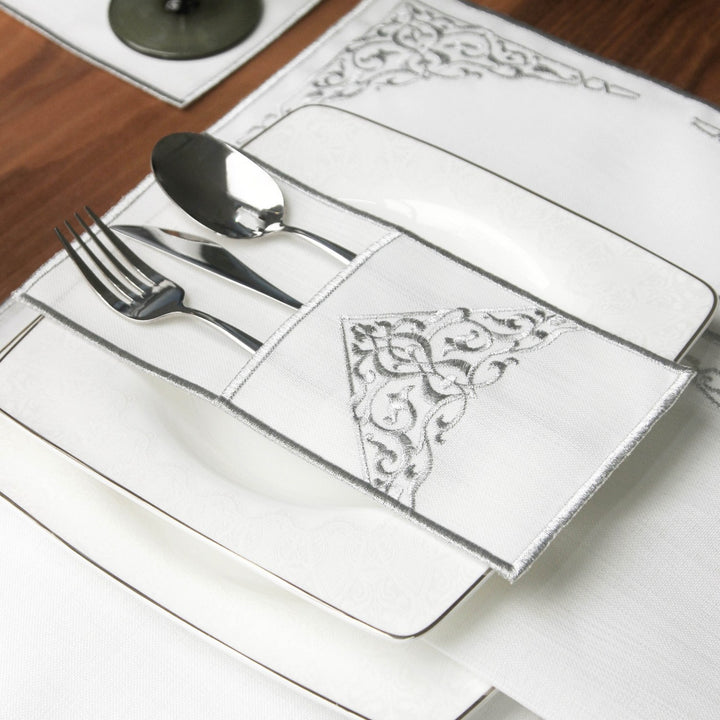 islamicwallart tasarimi olan gumus nakisli sette catal bicak ve kasik sik bir servis cebi icinde tabak uzerinde sunulmaktadir