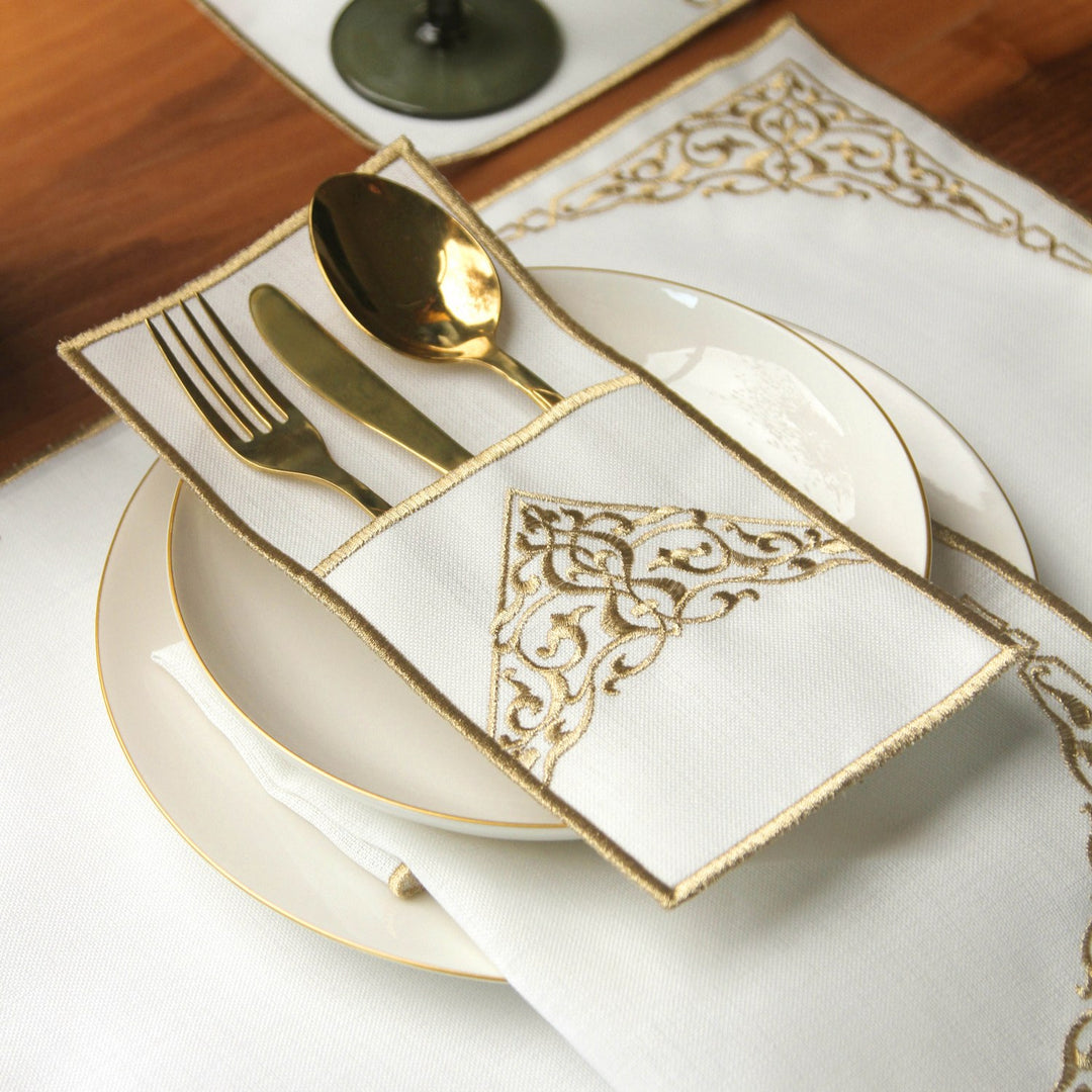 islamicwallart tasarimi olan bu sik sofrada beyaz kumas uzerine altin rengi nakis islemeli servis cebi icerisinde altin sarisi catal bicak ve kasik takimi bulunmaktadir