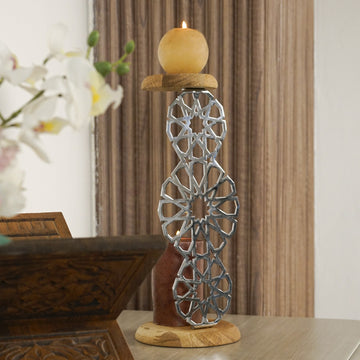 Parlak Gümüş geometrik metal mumluk, üstteki ahşap tablada yanan mumla, rahle yanında