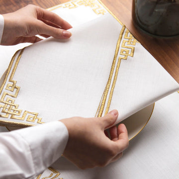 Ehlen ve Sehlen sofra setinin kırık beyaz peçetesi ve altın nakışlı geometrik kenarı, yakın çekim