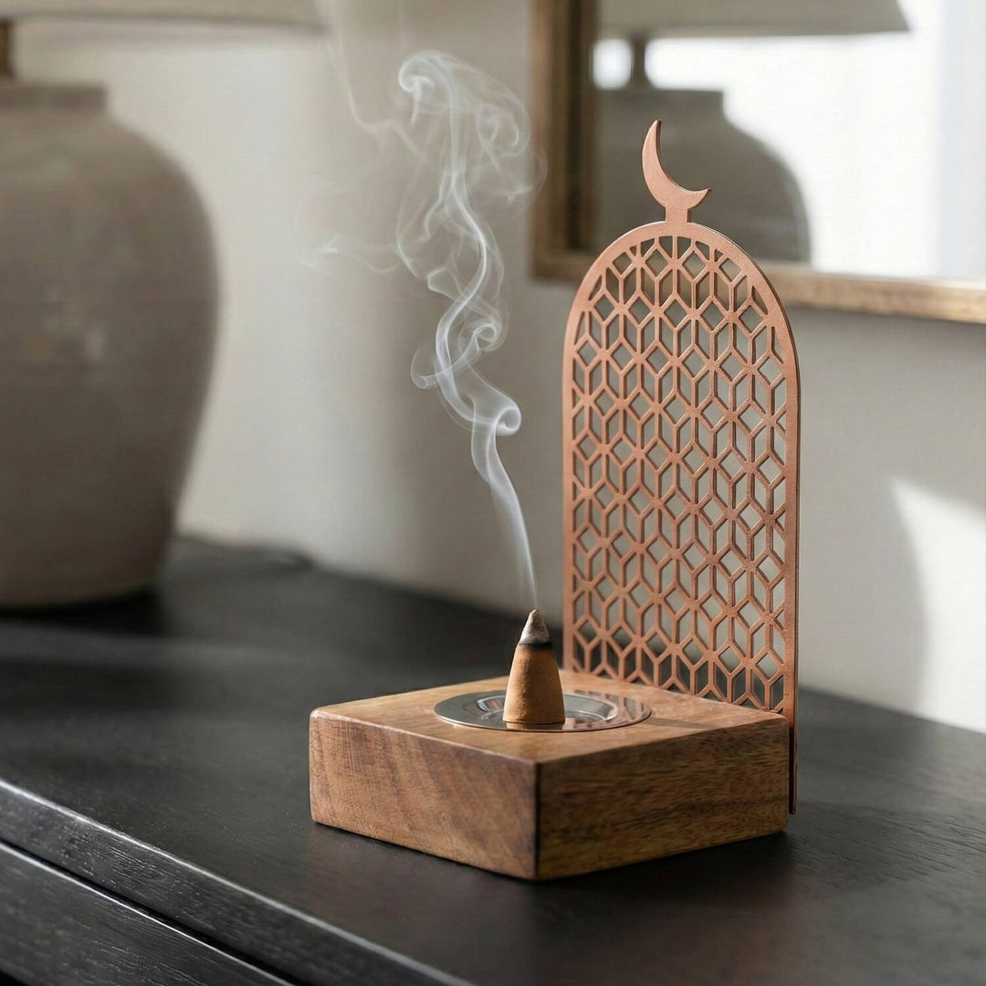 Geometrik desenli bakır metal tütsülük, ahşap standın üstünde yanan tütsüyle yandan görünüm