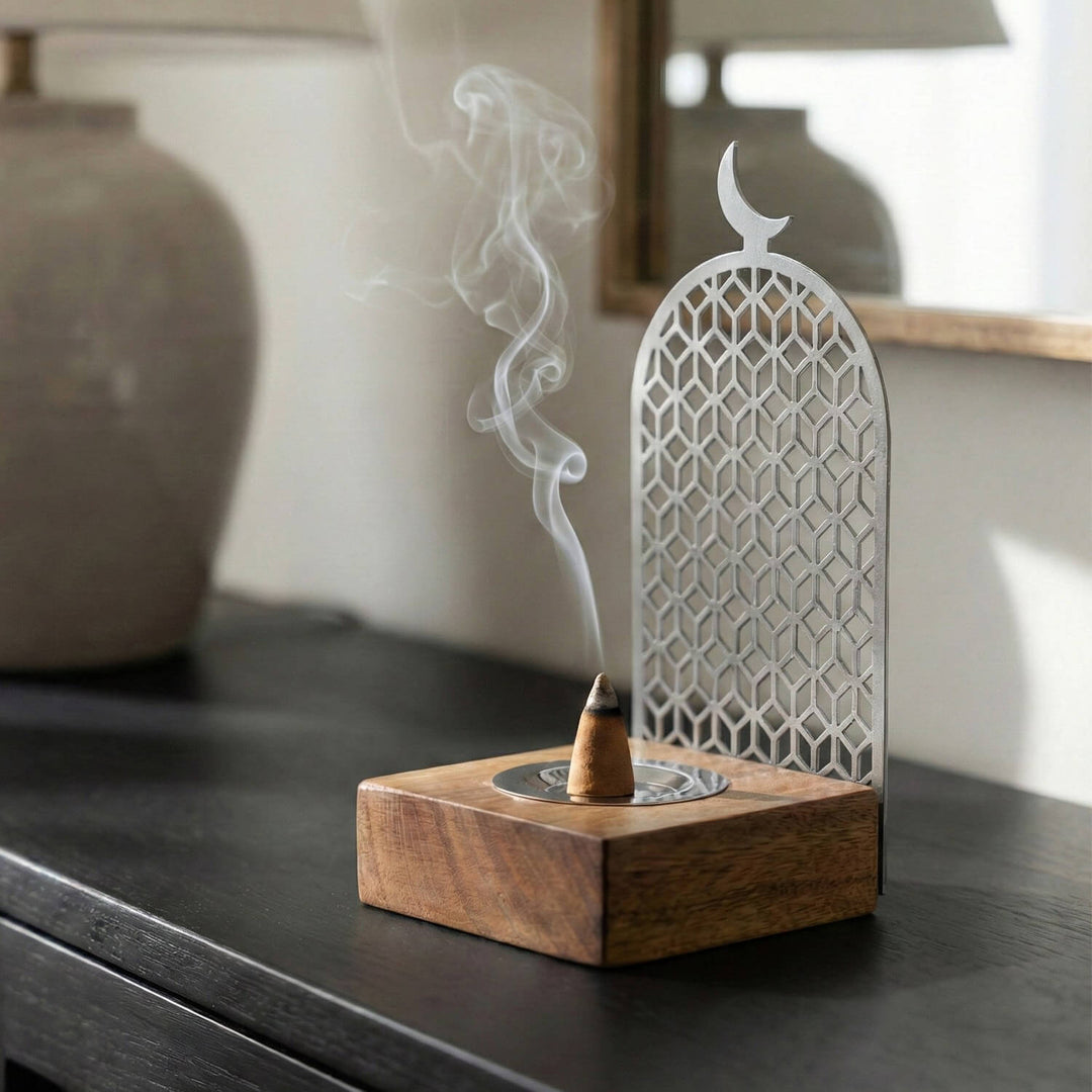 Geometrik desenli gümüş metal tütsülük ve ahşap stand, yanan tütsüyle yandan görünüm