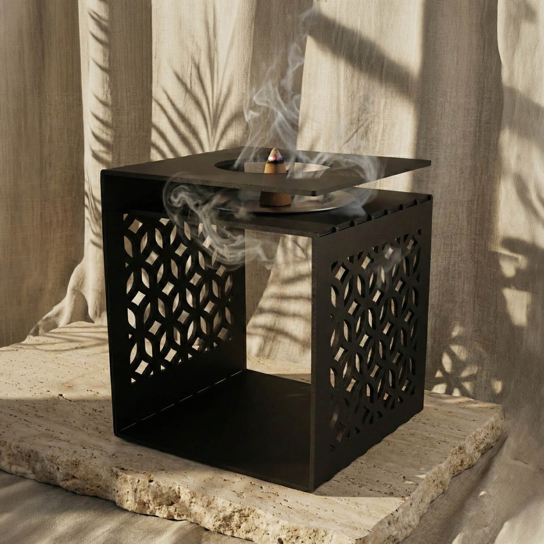 Siyah geometrik motifli metal buhurdanlık, açık yan yüzey ve tütsü dumanıyla yakın görünüm