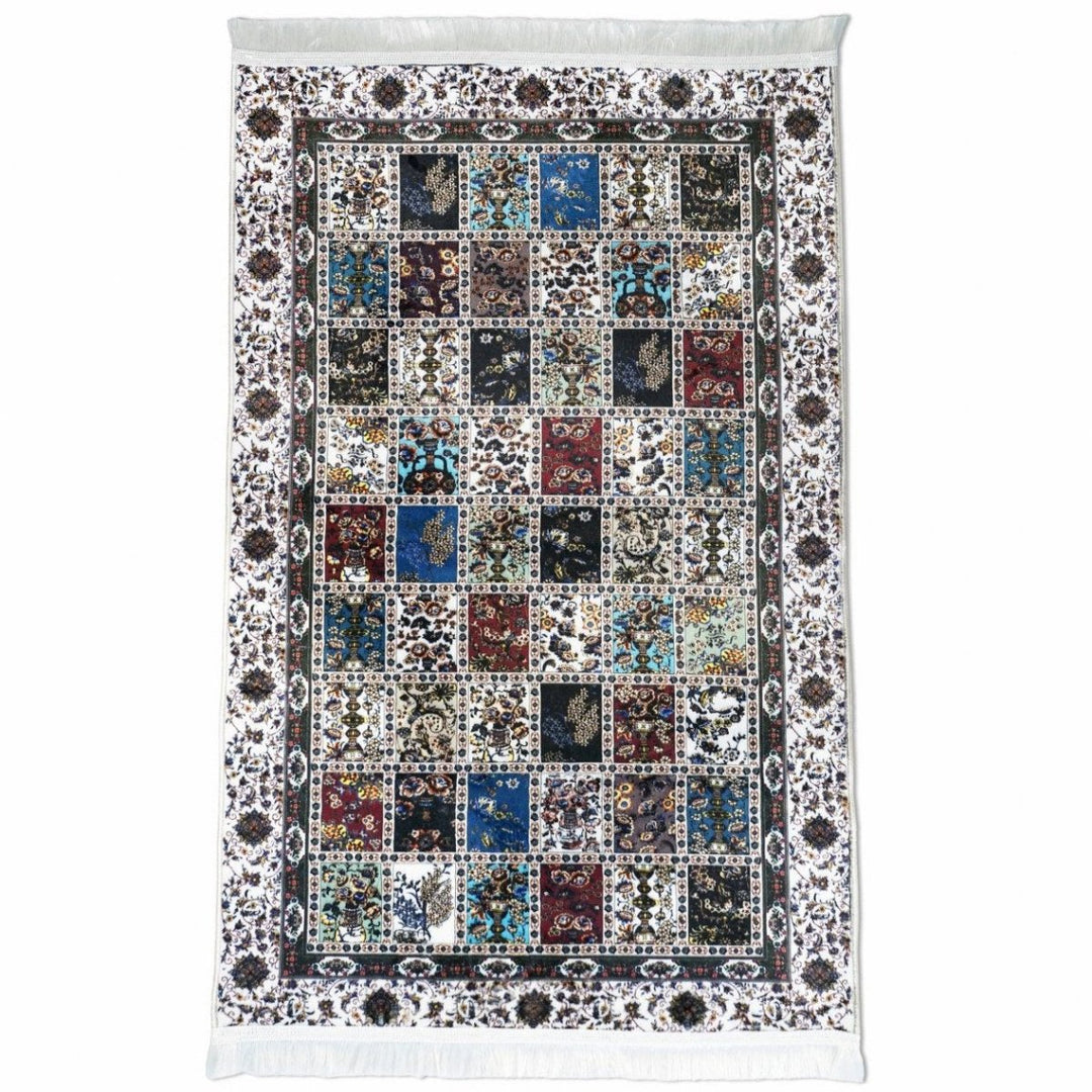 Çok renkli patchwork desenli seccade, çiçekli karo ızgarası ve beyaz püsküller, üstten görünüm
