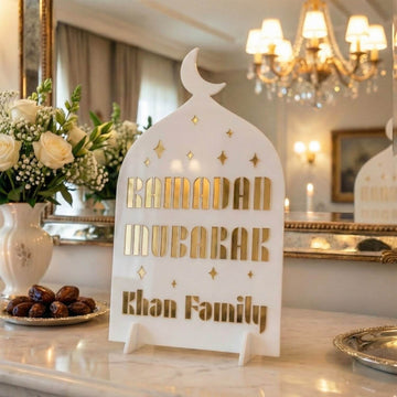 Aile İsimli Modern akrilik Ramazan masa üstü dekor, Dış Beyaz iç Altın, Khan Family yazılı, çiçeklerin yanında