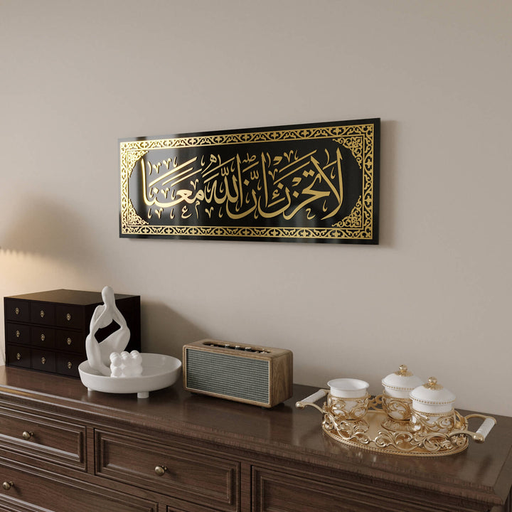 Kırılmaya karşı dirençli temperli cam yapısıyla uzun ömürlü La Tahzen İnnallahe Meana Cam Tablo - Tevbe Suresi 40. Ayet.
