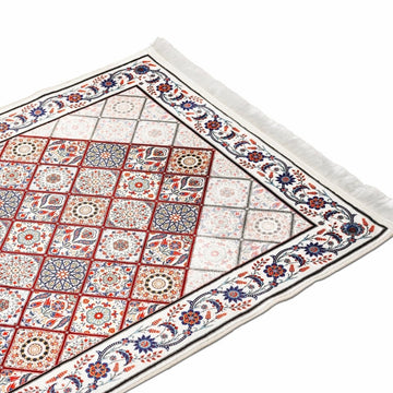 Kırmızı mavi geometrik desenli seccadenin çiçekli bordürlü köşesi, açılı görünüm