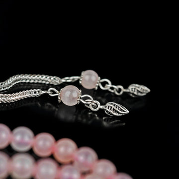 Pembe kuvars tesbihin gümüş renkli yaprak motifli püskül ve imame detayı, yakın çekim