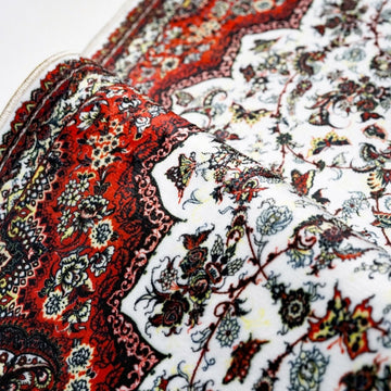 Beyaz kırmızı seccadenin katlanmış kenarı: süslemeli çiçek deseni yakın çekim