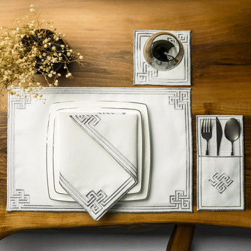 Gümüş nakışlı iftar seti, tabak üstündeki peçete, kese ve bardak altlığıyla üstten görünüm