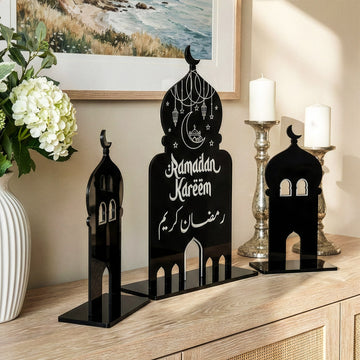 Kubbe ve iki minareden oluşan siyah akrilik Ramazan dekoru, vazo yanında