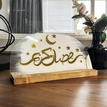 Beyaz zeminli Ramazan Kerim masa dekoru, altın yazı ve hilal ile yıldızlar, açılı çekim