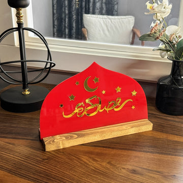 Kırmızı pleksi üzerinde altın akrilik Arapça Ramazan Kerim yazılı, ahşap standlı masa ve raf dekoru