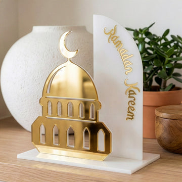 Buzlu üzeri altın akrilik cami silüetli Ramazan Kerim masa dekoru, beyaz zemin ve kubbe detayı