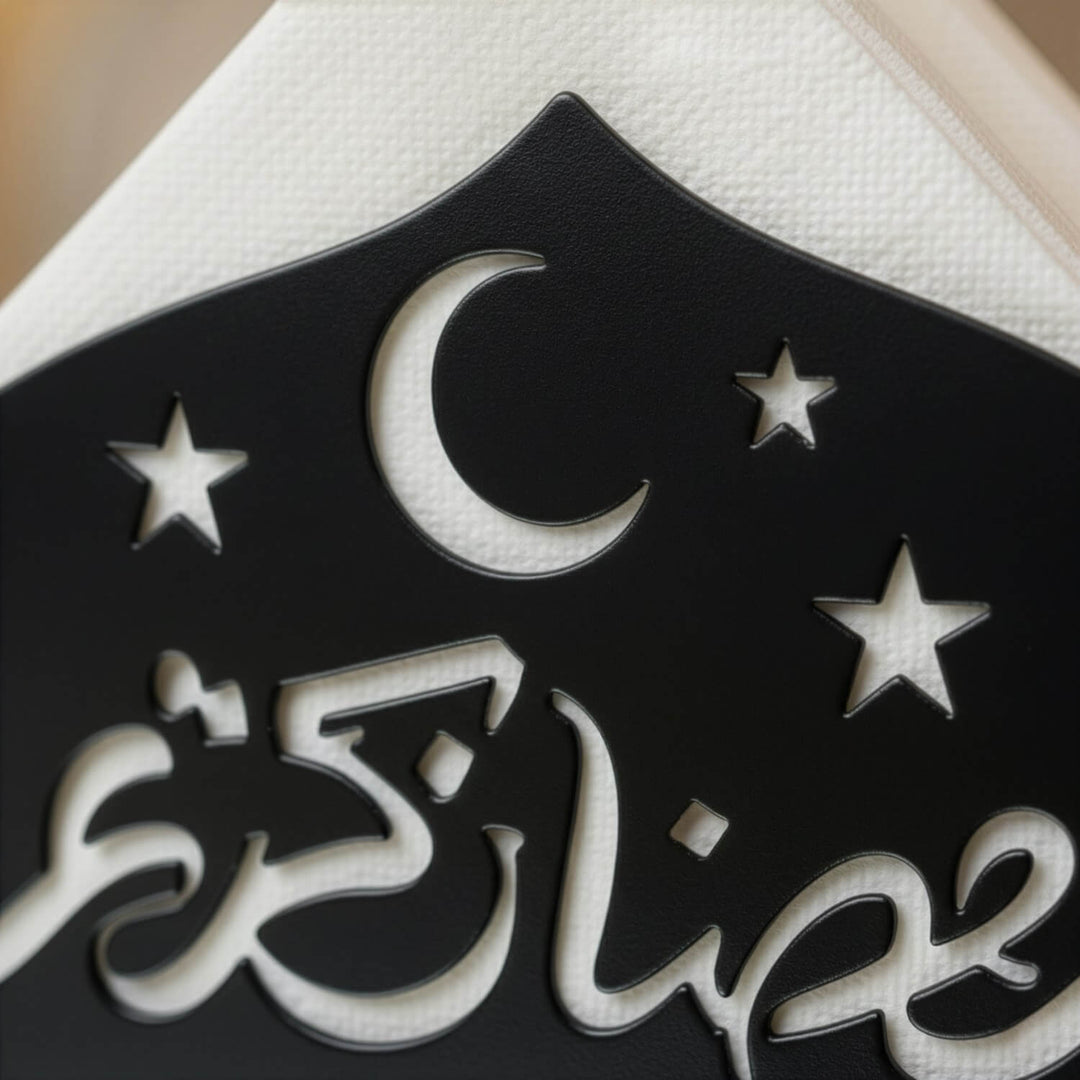 Ramazan Kerim yazısı, hilal ve yıldız kesimlerinin siyah metal peçetelik üzerinde yakın çekimi