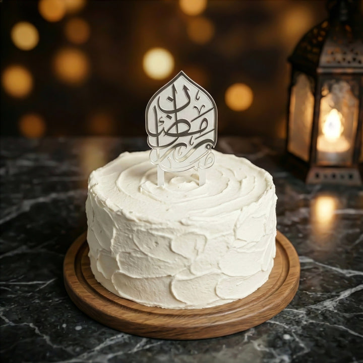 beyaz kremayla kapli yuvarlak pastanin uzerinde beyaz buzlu ayakli gumus renkli arapca ramazan kerim yazili akrilik kek topper islamicwallarttr