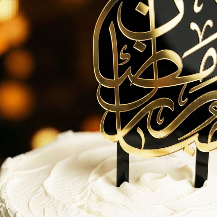 beyaz kremayla kapli pastanin uzerine yerlestirilmis siyah ayakli altin renkli arapca ramazan kerim yazili akrilik kek topper detay cekimi islamicwallarttr