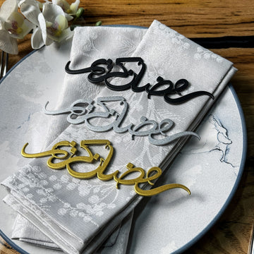 Siyah, gümüş ve altın Ramazan Kerim peçete süsleri, açık renk peçetenin üzerinde üst üste dizilmiş