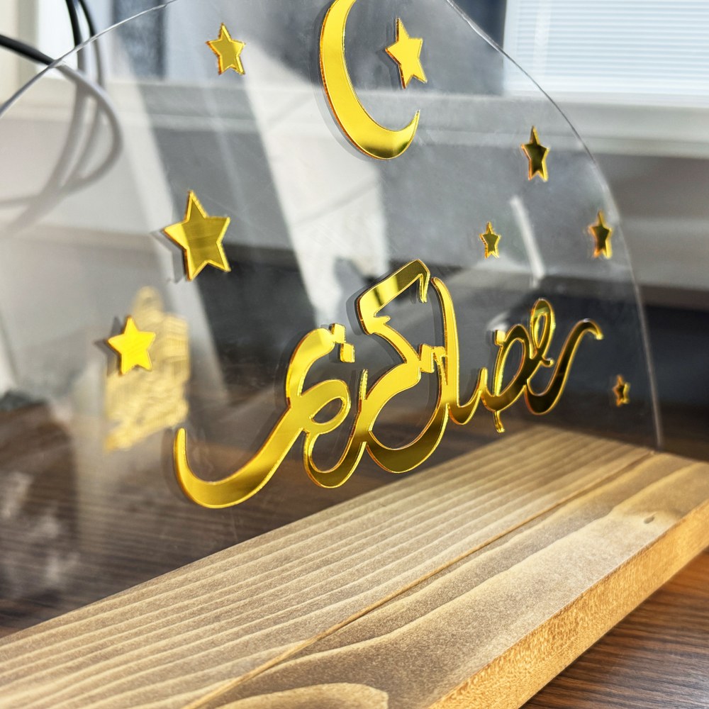 Şeffaf pleksi ve ahşap stand birleşimi, altın Ramazan Kerim yazısının yakın detay çekimi