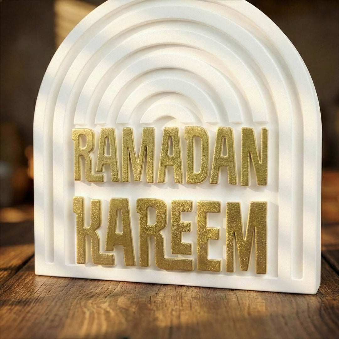 Altın yaldızlı yazılı kemerli taş dekor, ahşap masada alçak açıdan yakın görünüm