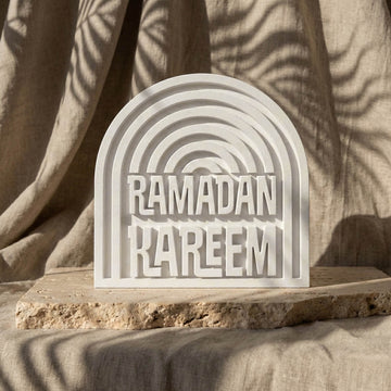 Kemerli beyaz taş dekor üzerindeki kabartma Ramazan Kerim yazısı, taş plakada hafif açılı görünüm