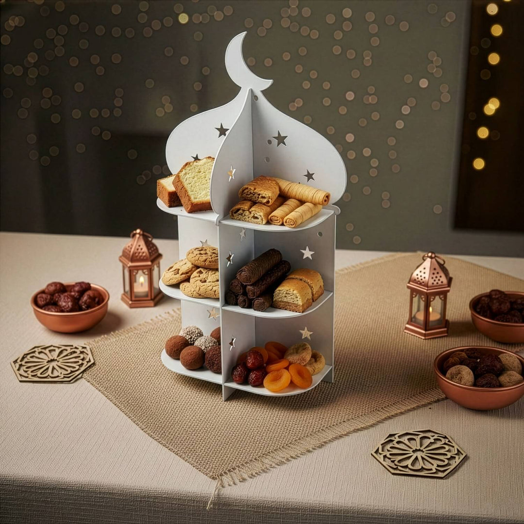 Beyaz minare sunum standı, hurma kaseleri ve bakır fenerlerin bulunduğu iftar masasında geniş çekim