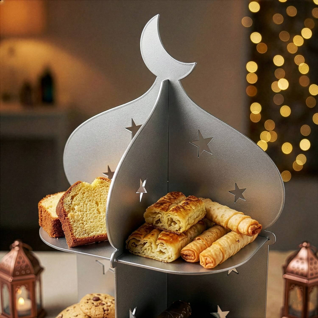 Gümüş metal minare standının üst katındaki börek ve kek dilimleri, yıldız oymalı panelle yakın çekim