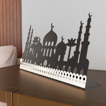 Cami silüetli siyah metal masaüstü Ramazan takvimi, günleri gösteren beyaz şeritle açılı görünüm