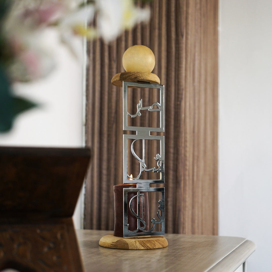 Parlak gümüş Sabır Şükür Tevekkül yazılı metal mumluk, perde önünde rahleyle