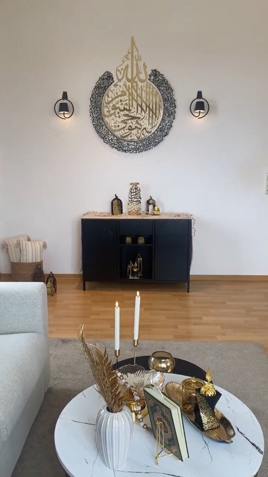 Salonda duvarda yuvarlak Ayetel Kürsi tablosu, önünde sehpa ve mumlar
