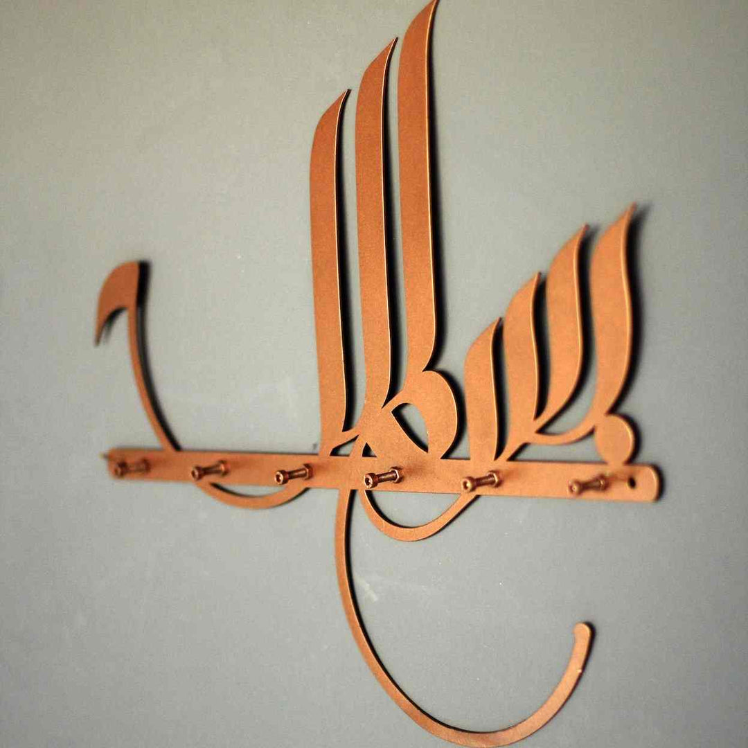 Bakır Besmele hat yazılı metal anahtarlık, açık gri duvarda çengel sırasıyla