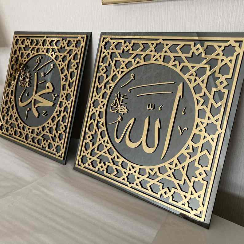 Allah (c.c.) ve Muhammed (s.a.v) lafızlı iki altın akrilik temperli cam tablo, yan yana duvara dayalı