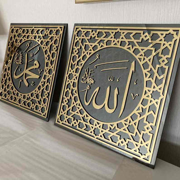 Allah (c.c.) ve Muhammed (s.a.v) lafızlı iki altın akrilik temperli cam tablo, yan yana duvara dayalı