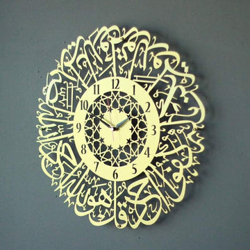 Altın İhlas Suresi Latin rakamlı desenli metal duvar saati, yıldız desenli iç halkalı, gri duvarda