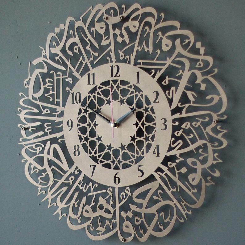 Bakır İhlas Suresi Latin rakamlı desenli metal duvar saati, yıldız desenli iç halkalı, gri duvarda