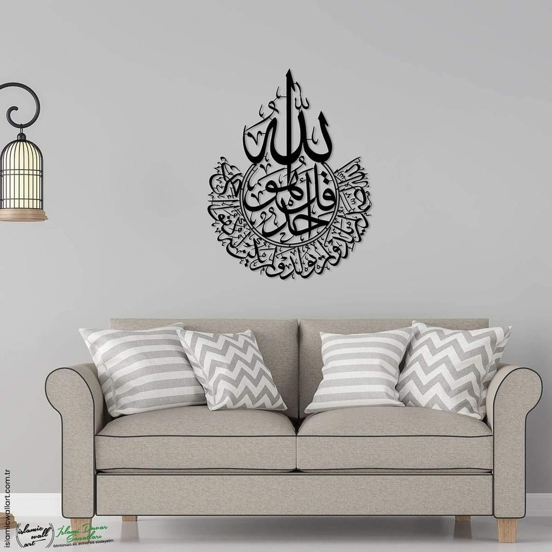 Siyah İhlas Suresi lafızlı metal tablo, gri duvarda kanepenin üstünde, Allah lafzı ve İhlas Suresi hattı