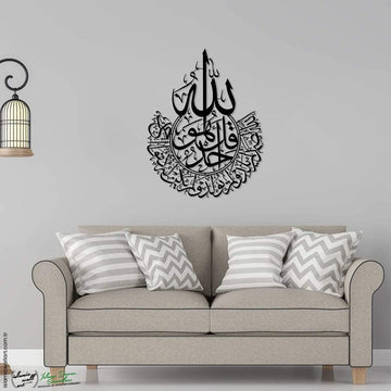 Siyah İhlas Suresi lafızlı metal tablo, gri duvarda kanepenin üstünde, Allah lafzı ve İhlas Suresi hattı
