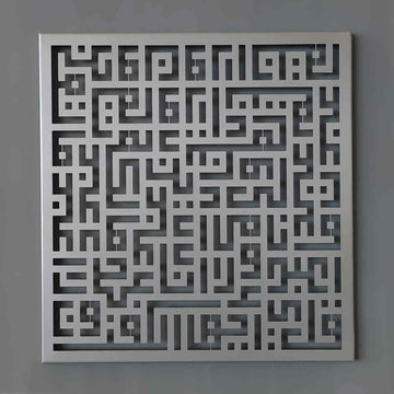 Gümüş Kufi hatlı Kafirun Suresi metal tablo, gri duvarda önden tam görünüm