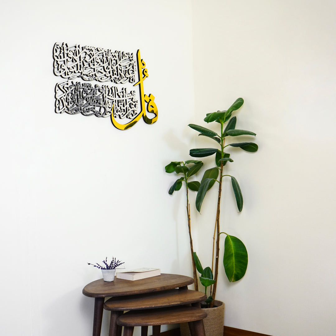 Kul suresi ahşap akrilik tablo, sol üstte asılı, ficus bitkisi ve oval sehpanın üstünde